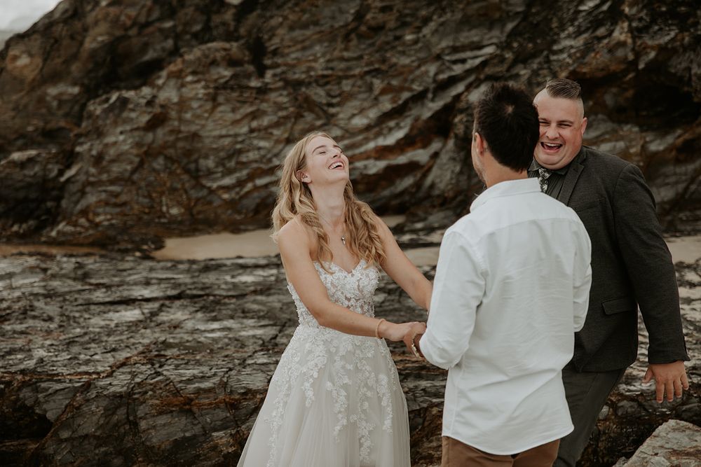 Alana laughing with Nathan and Josh during their Currumbin Rock elopement ceremony