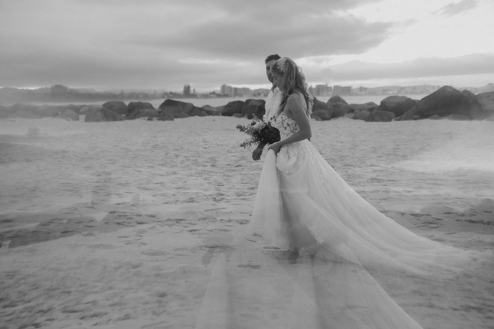 Alana and Nathan walking together on Currumbin Beach after their elopement