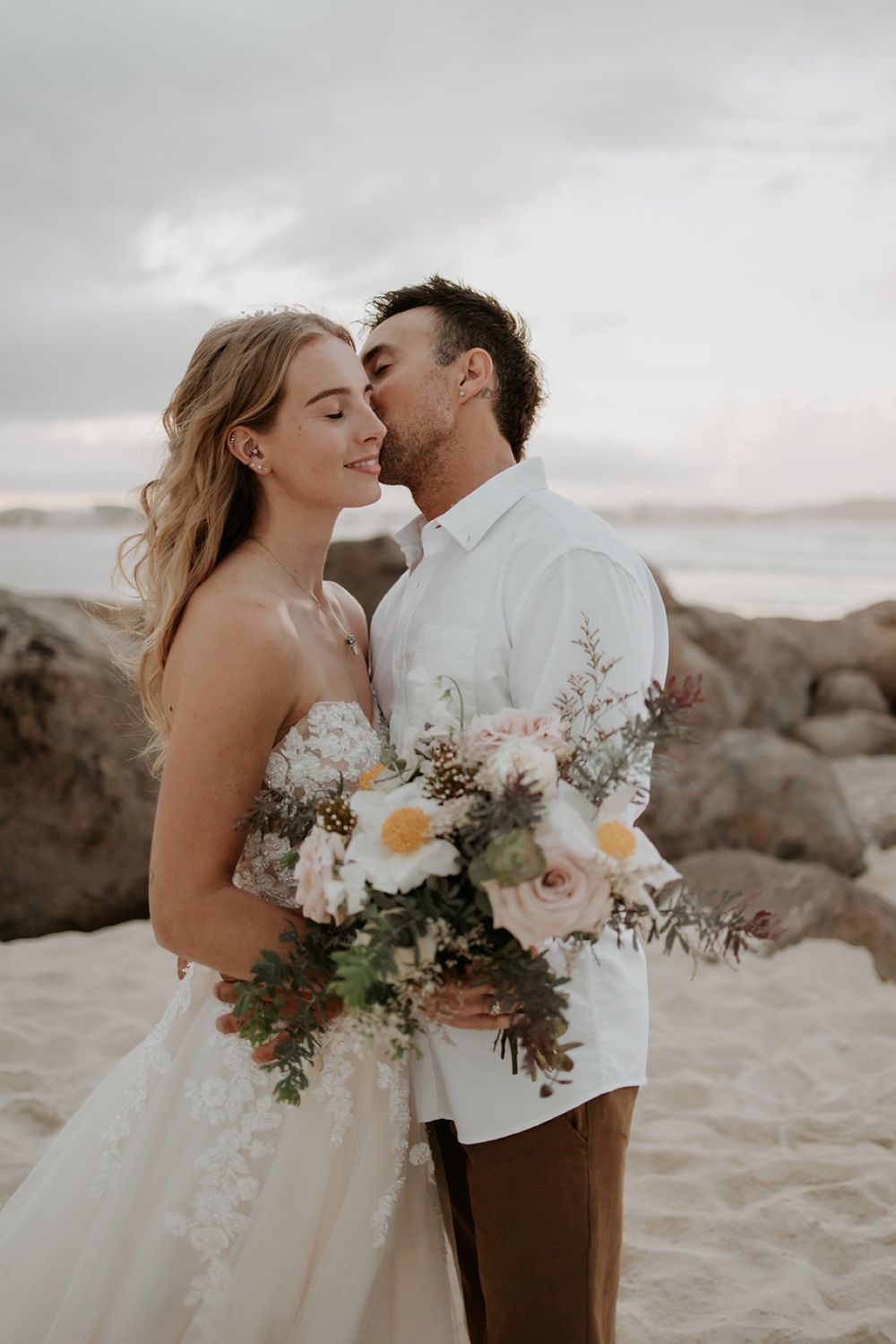 Nathan kissing Alana’s forehead on Currumbin Beach after their wedding ceremony