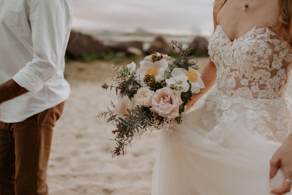Alana holding her wedding bouquet on Currumbin Beach