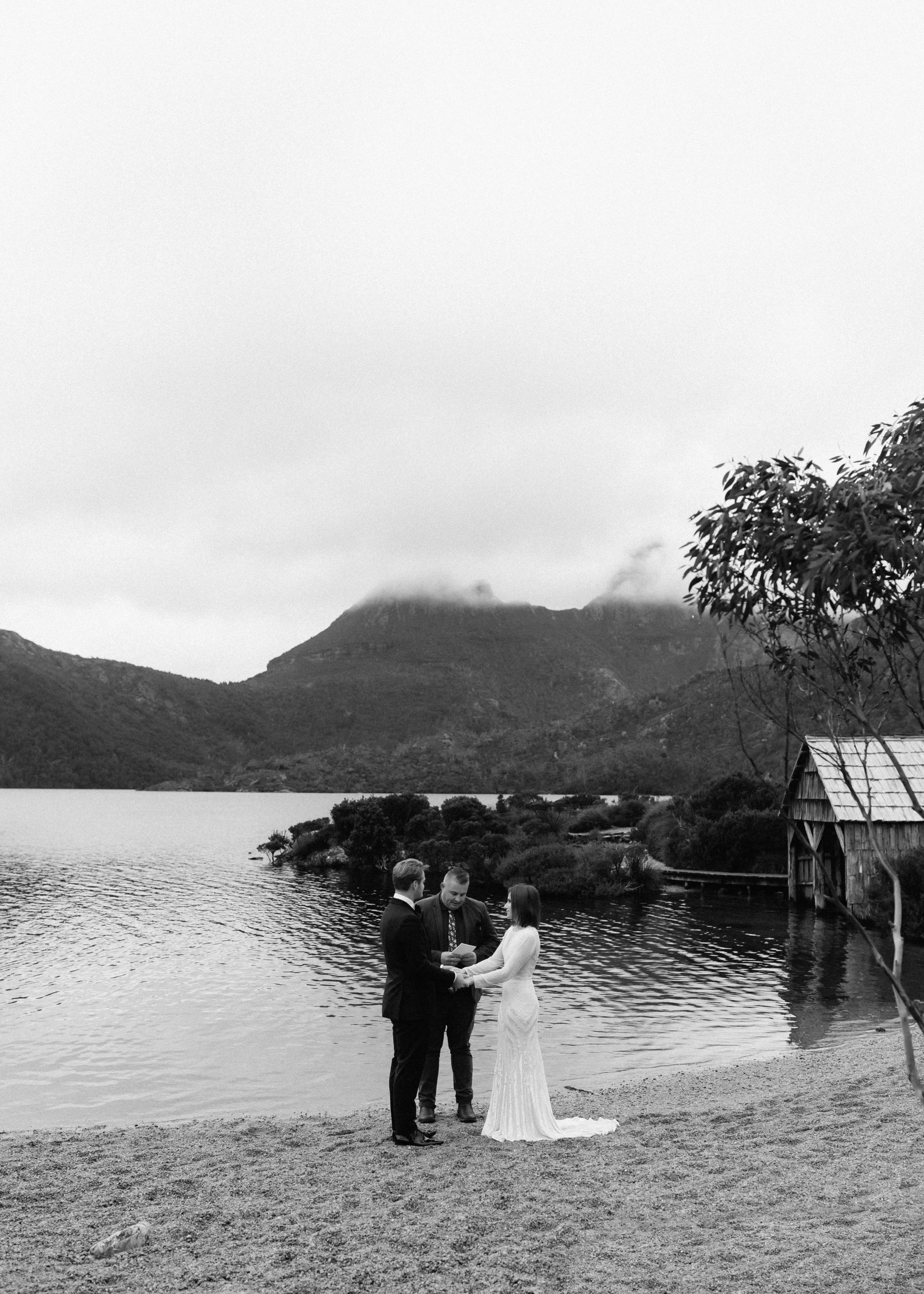 A couple exchanging vows with Josh Withers beside Dove Lake at Cradle Mountain