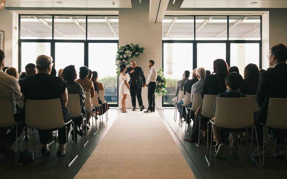 Friends and family watching Deb and Mickey’s ceremony in a room overlooking the water