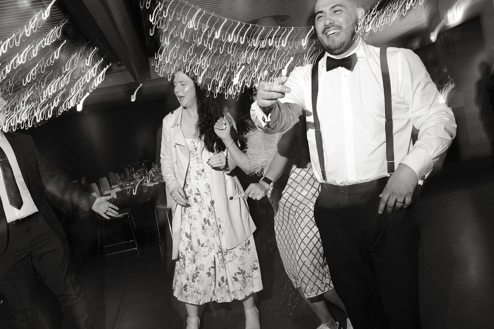 Black and white photograph of Deb and Mickey celebrating on the dance floor with their guests