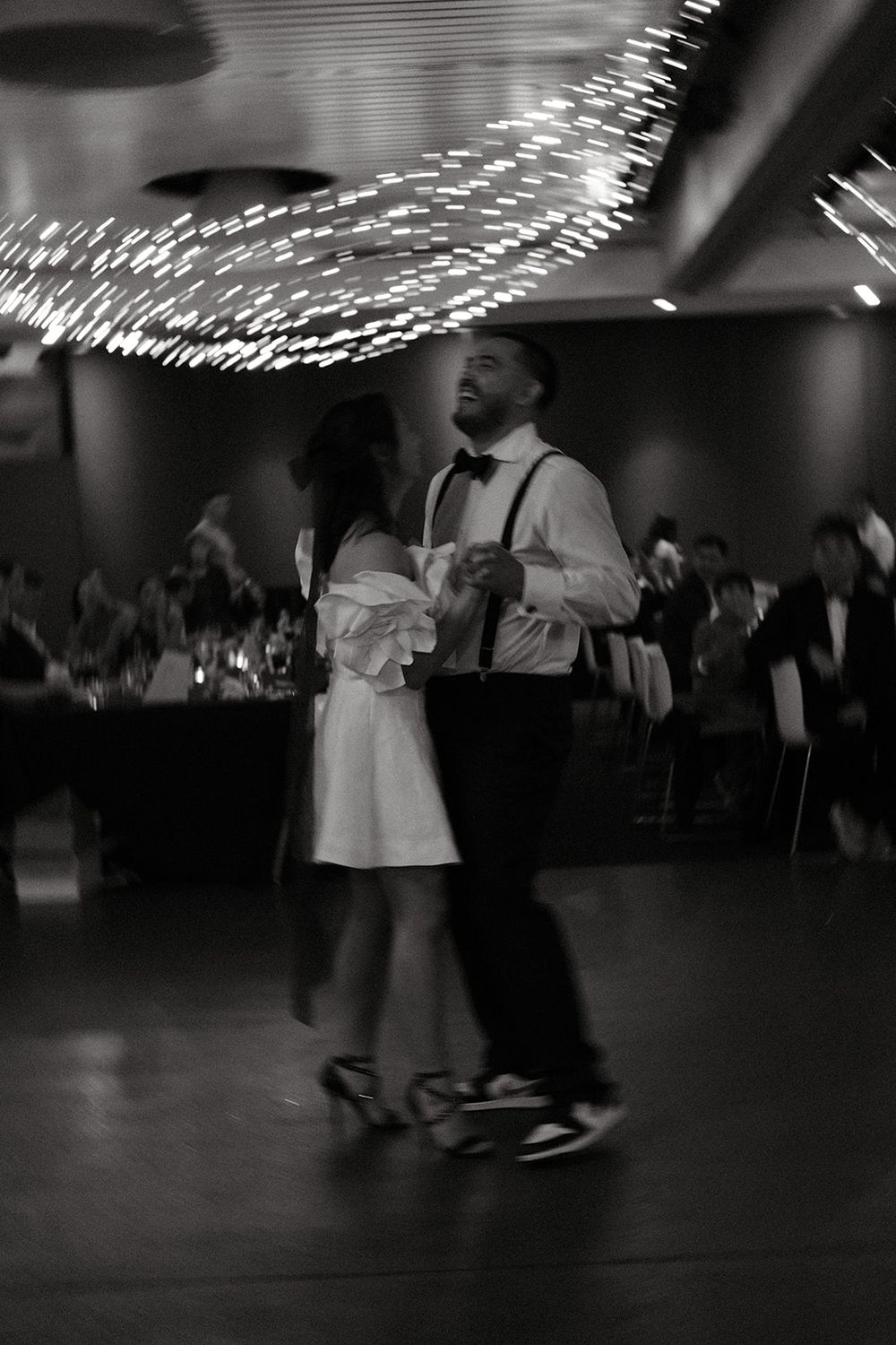 Black and white photograph of Deb and Mickey dancing together beneath fairy lights