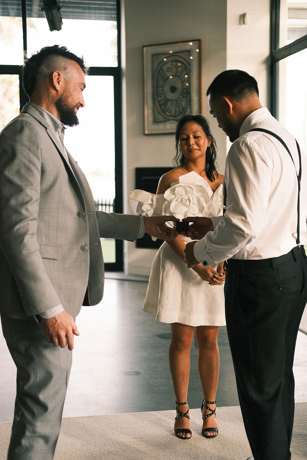 Josh Withers standing beside Deb and Mickey as they exchange wedding rings