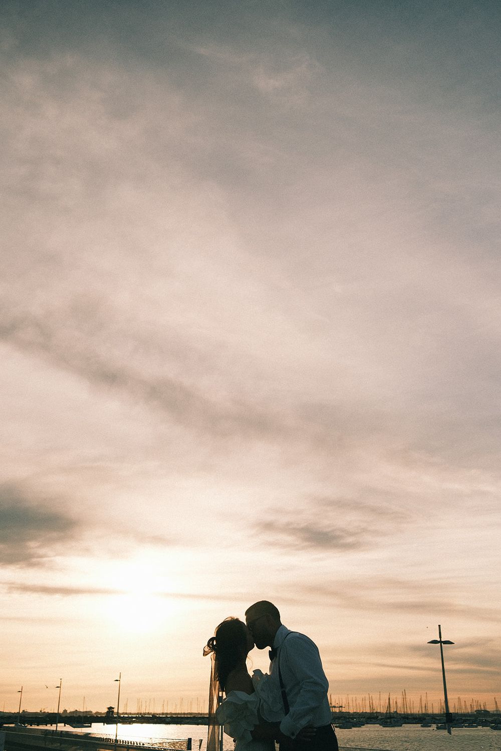 Deb and Mickey silhouetted together beneath a pink and gold sunset sky