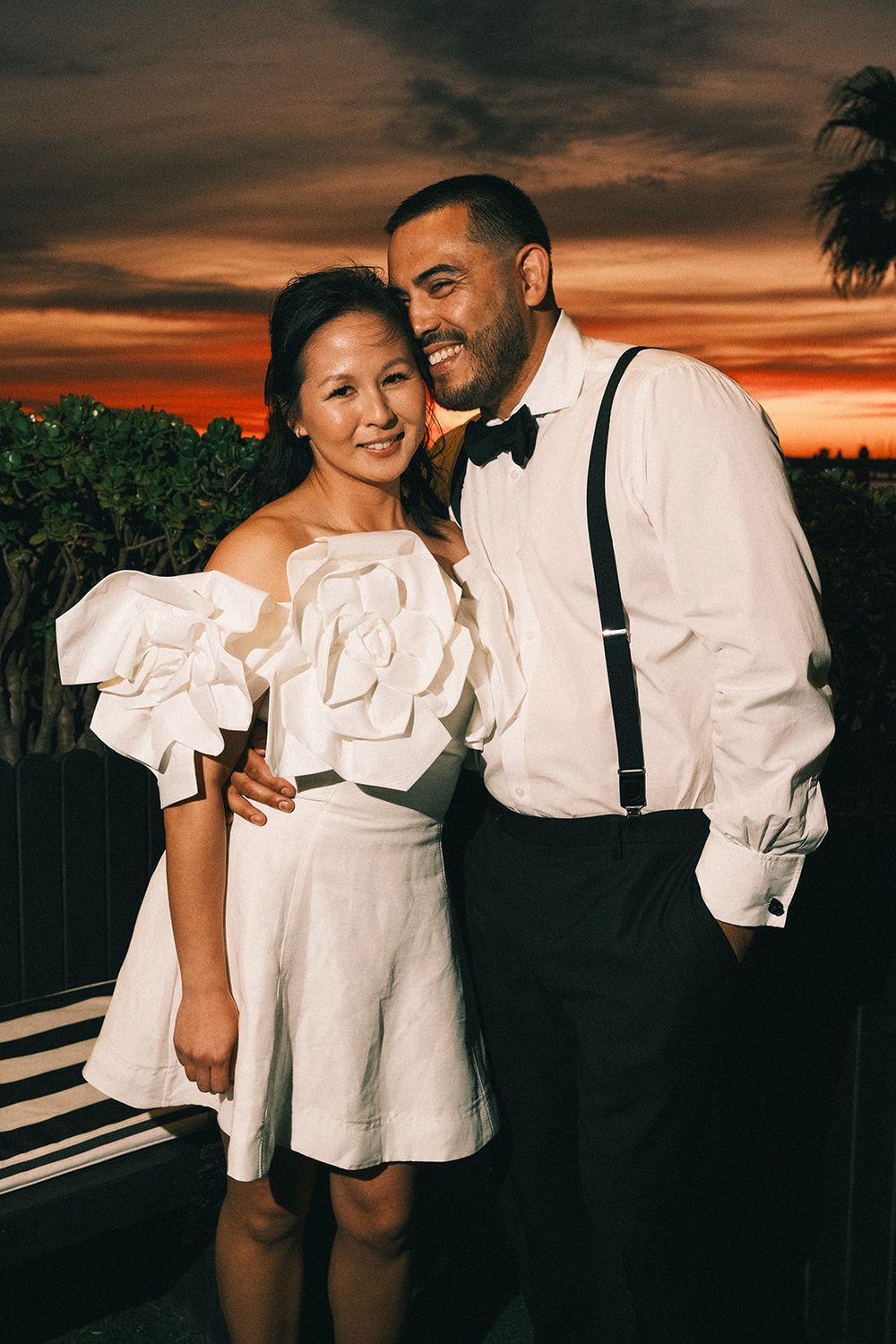 Deb and Mickey smiling together with the orange sunset behind them