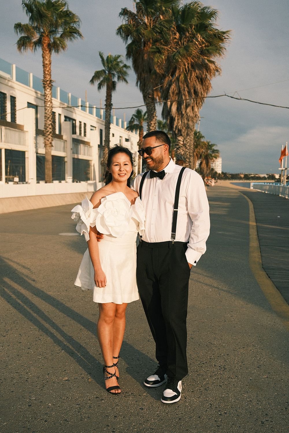 Deb and Mickey walking together along the waterfront in the afternoon light