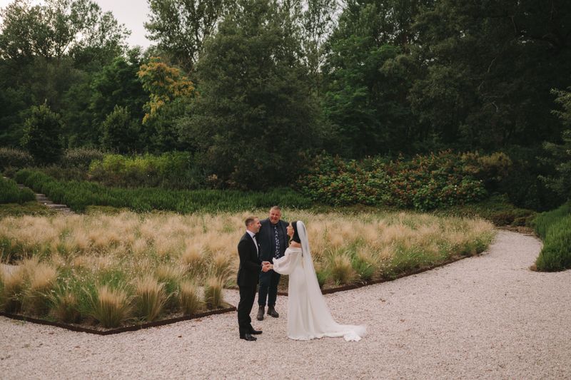 Harry and Nayla laughing with Josh during their garden ceremony at Vocabolo Moscatelli in Umbria
