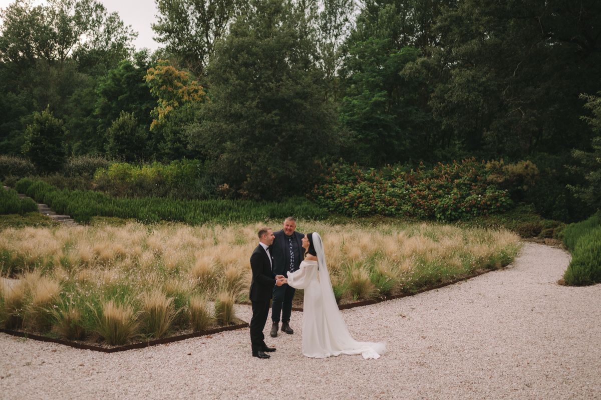 Harry and Nayla laughing with Josh during their garden ceremony at Vocabolo Moscatelli in Umbria
