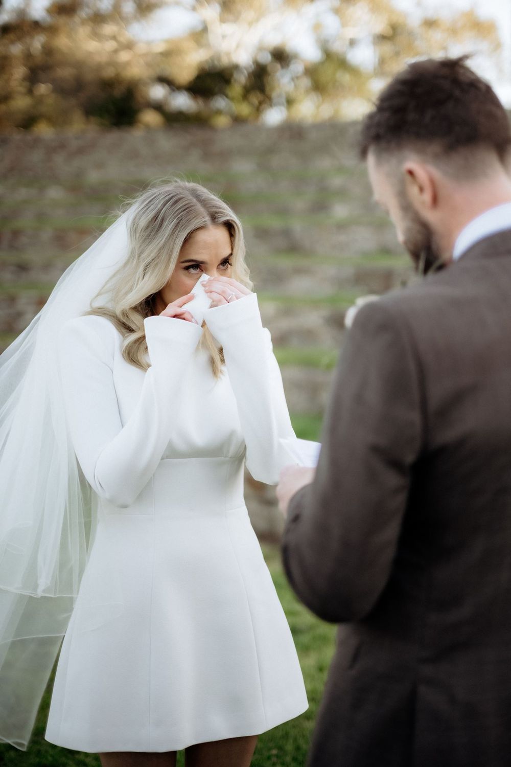 Kaitlyn wiping a tear during her vows to Russell at Piermont Retreat