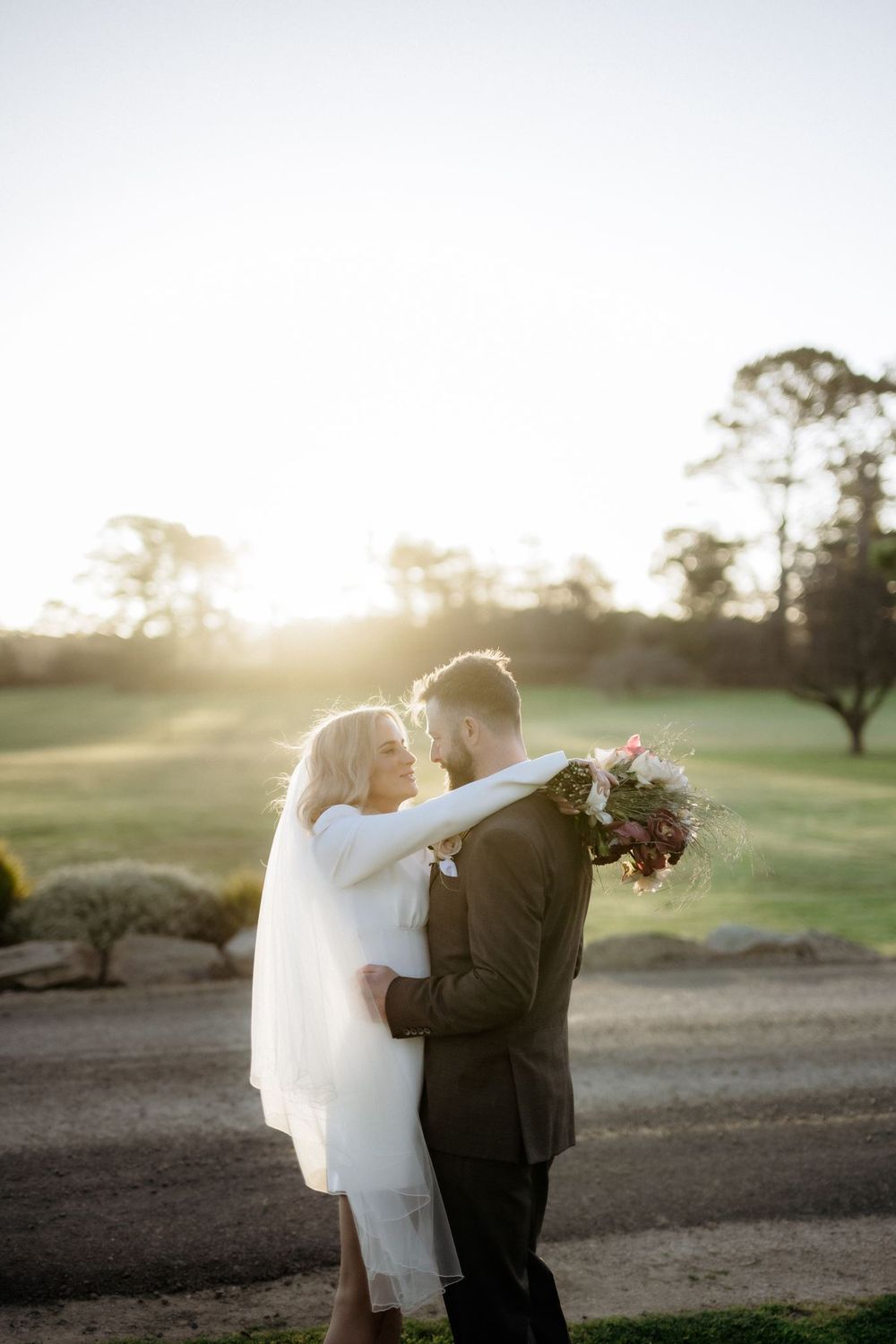 Kaitlyn and Russell embracing in the low afternoon light at Piermont Retreat