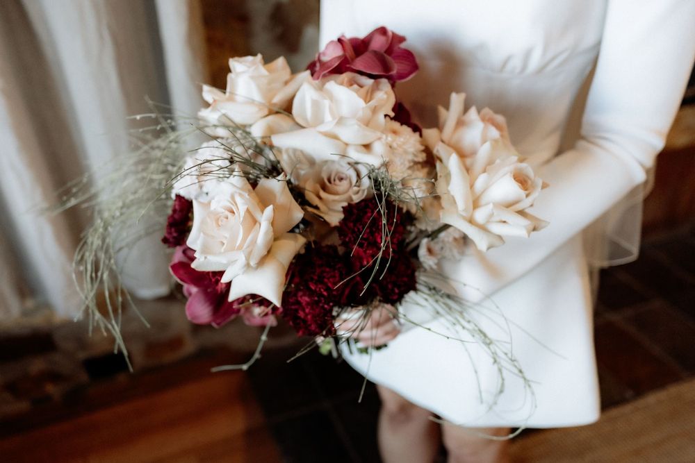 Kaitlyn holding her cream and burgundy bouquet by The Romantics