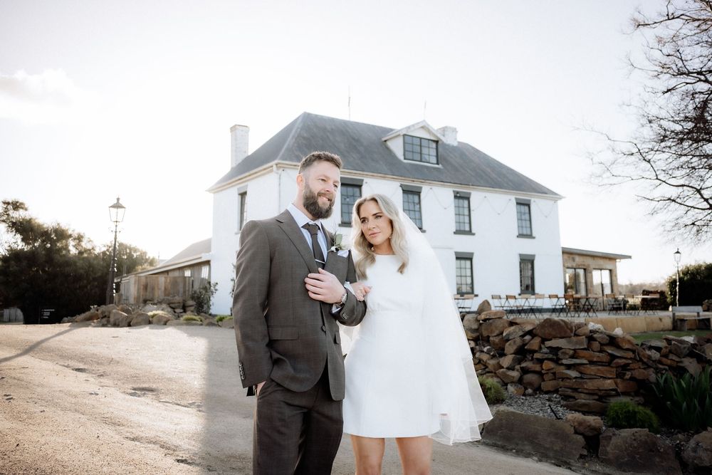 Kaitlyn and Russell standing outside Piermont Retreat’s white Georgian Homestead