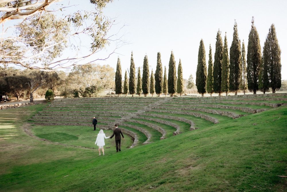 Kaitlyn and Russell walking into Piermont Retreat’s curved stone amphitheatre for their ceremony