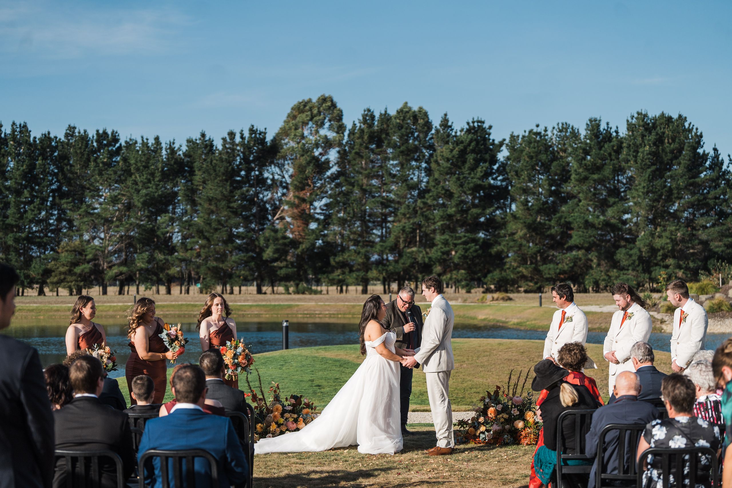 Josh Withers conducting an outdoor wedding ceremony beside a lake in Launceston