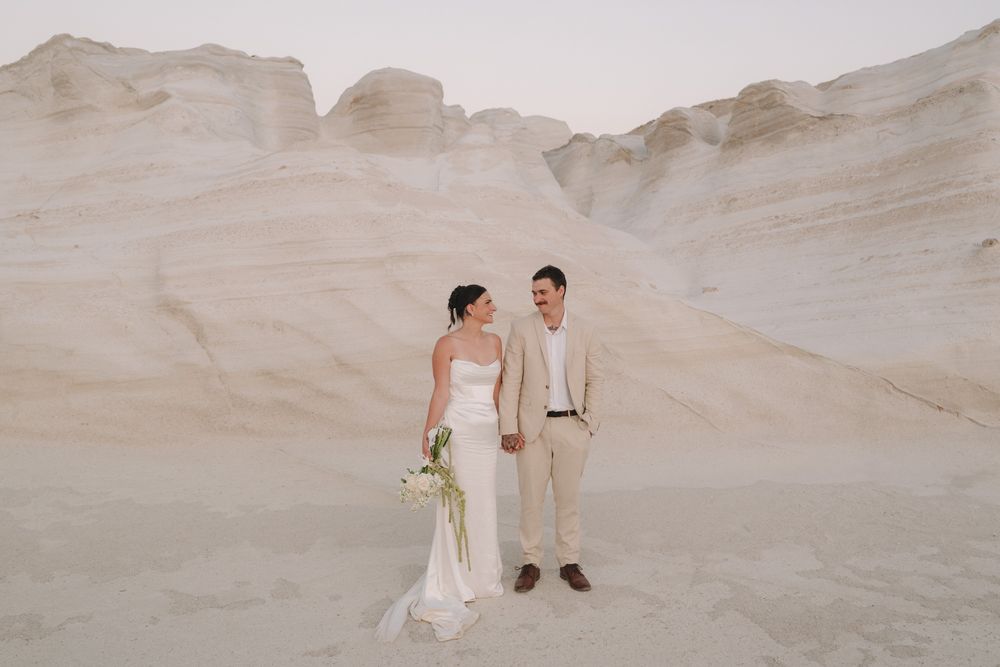 Tiegan and Michael standing against the white volcanic landscape at Sarakiniko Beach, Milos